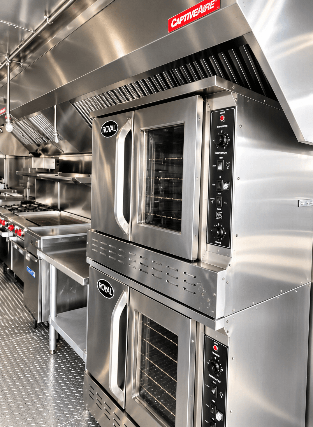 Stacked commercial convection ovens beneath an extraction hood